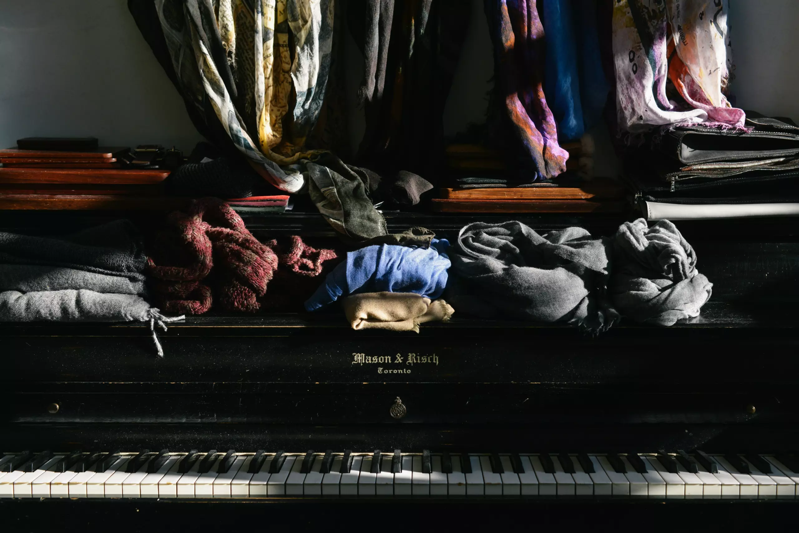 Chaotische Kleidersammlung auf einem Klavier